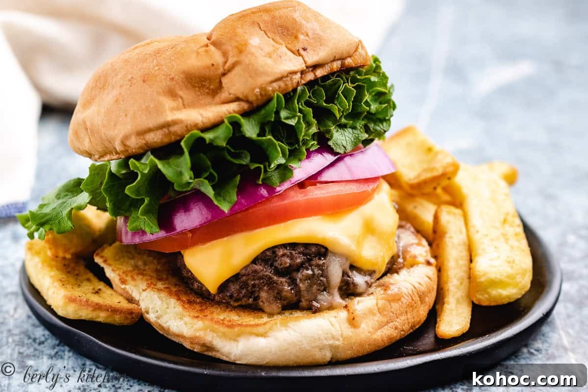 Stuffed burger topped with lettuce, tomato and cheese.