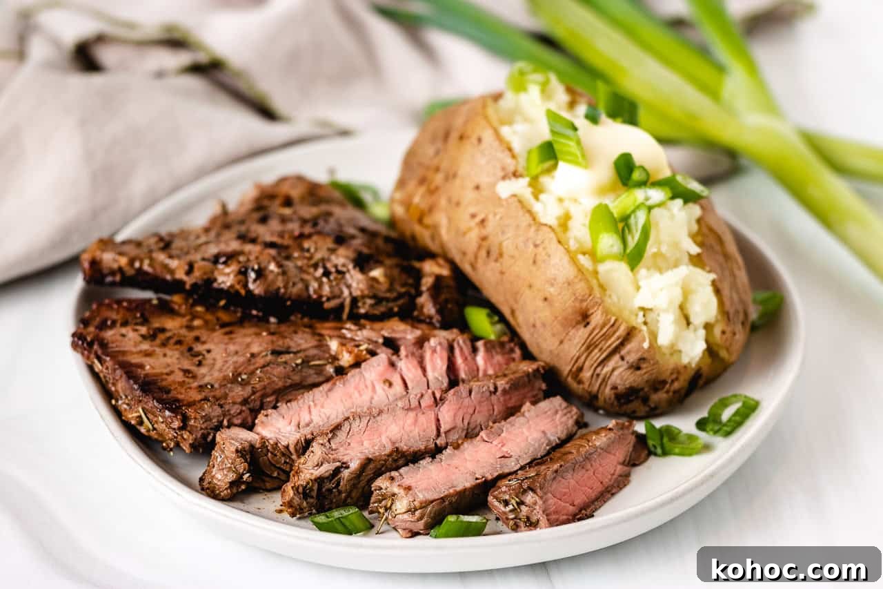 Sliced sirloin steak with a baked potato with butter.