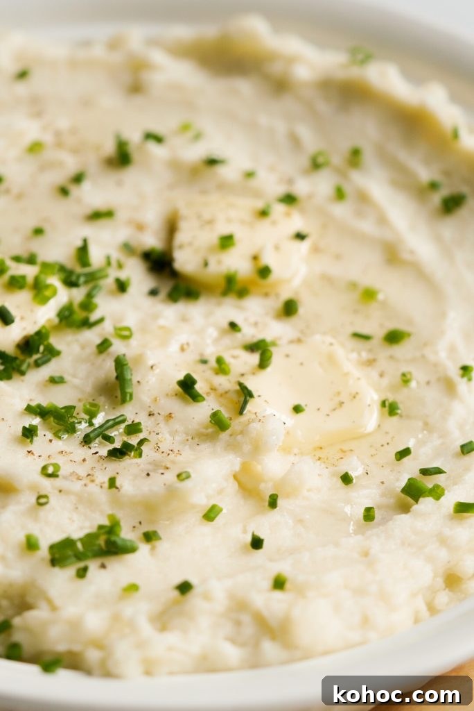 Truffle Mashed Potatoes Recipe: Creamy Garlic Parmesan Mash 12 close up shot of potatoes topped with fresh chives and butter