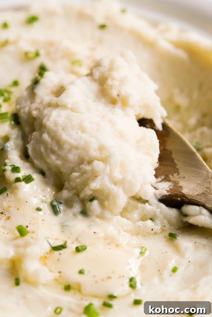 Truffle Mashed Potatoes Recipe: Creamy Garlic Parmesan Mash 3 close up shot of wooden spoon scooping mashed potatoes