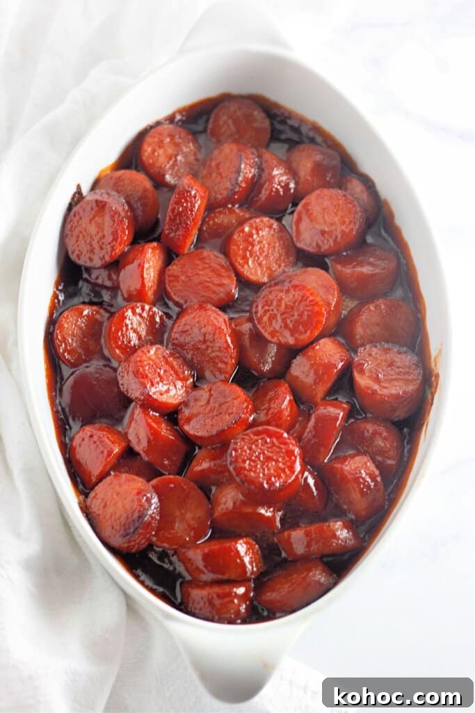 Oven-Baked BBQ Kielbasa Roast: Sweet Glazed Sausage Recipe 8 Baked kielbasa in a white casserole dish.