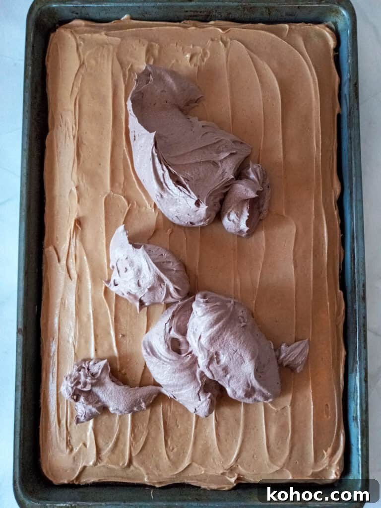 Amish-Style Reese’s Peanut Butter Bars Recipe for Dessert 5 spreading chocolate frosting over top of the peanut butter layer