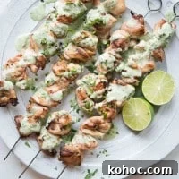 Citrus Chicken with Cilantro-Garlic Sauce Recipe 3 overhead view of skewers of Citrus Chicken with Cilantro Garlic Sauce on a white plate