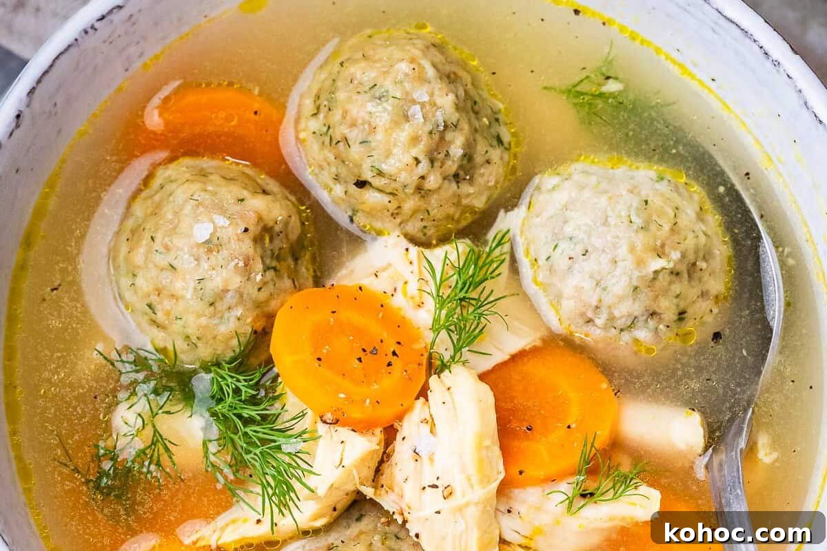 Classic Matzo Ball Soup Recipe: Cozy Homemade Comfort Soup 8 A closeup of matzo ball soup in a white bowl