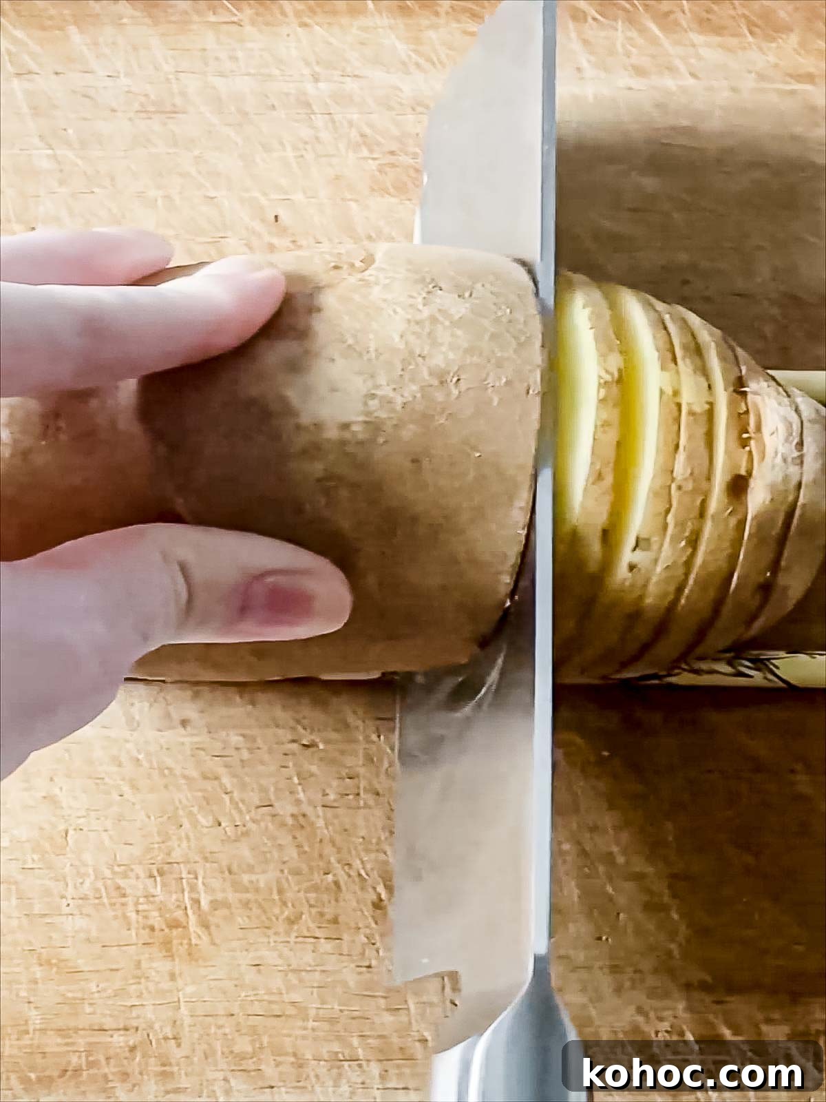 Crispy Air Fryer Hasselback Potatoes with Garlic and Herbs 4 Knife cutting a potato.
