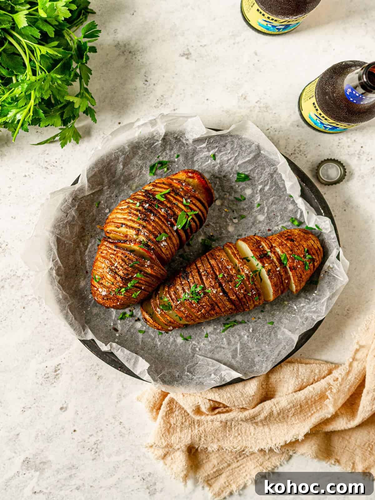 Crispy Air Fryer Hasselback Potatoes with Garlic and Herbs 6 Air fryer hasselback potatoes next to two beer bottles.