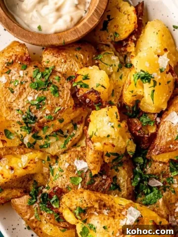 Smashed yellow potatoes topped with chopped parsley.
