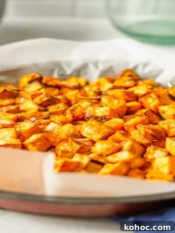 Air fried sweet potato cubes in a basket on a blue cloth