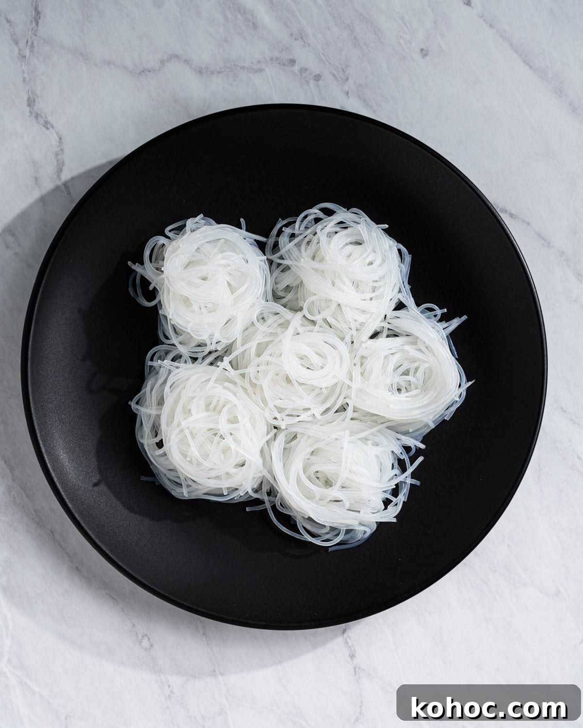 Perfect Rice Noodles: How to Cook Them Without Overcooking 10 swirls of cooked vermicelli on a plate.