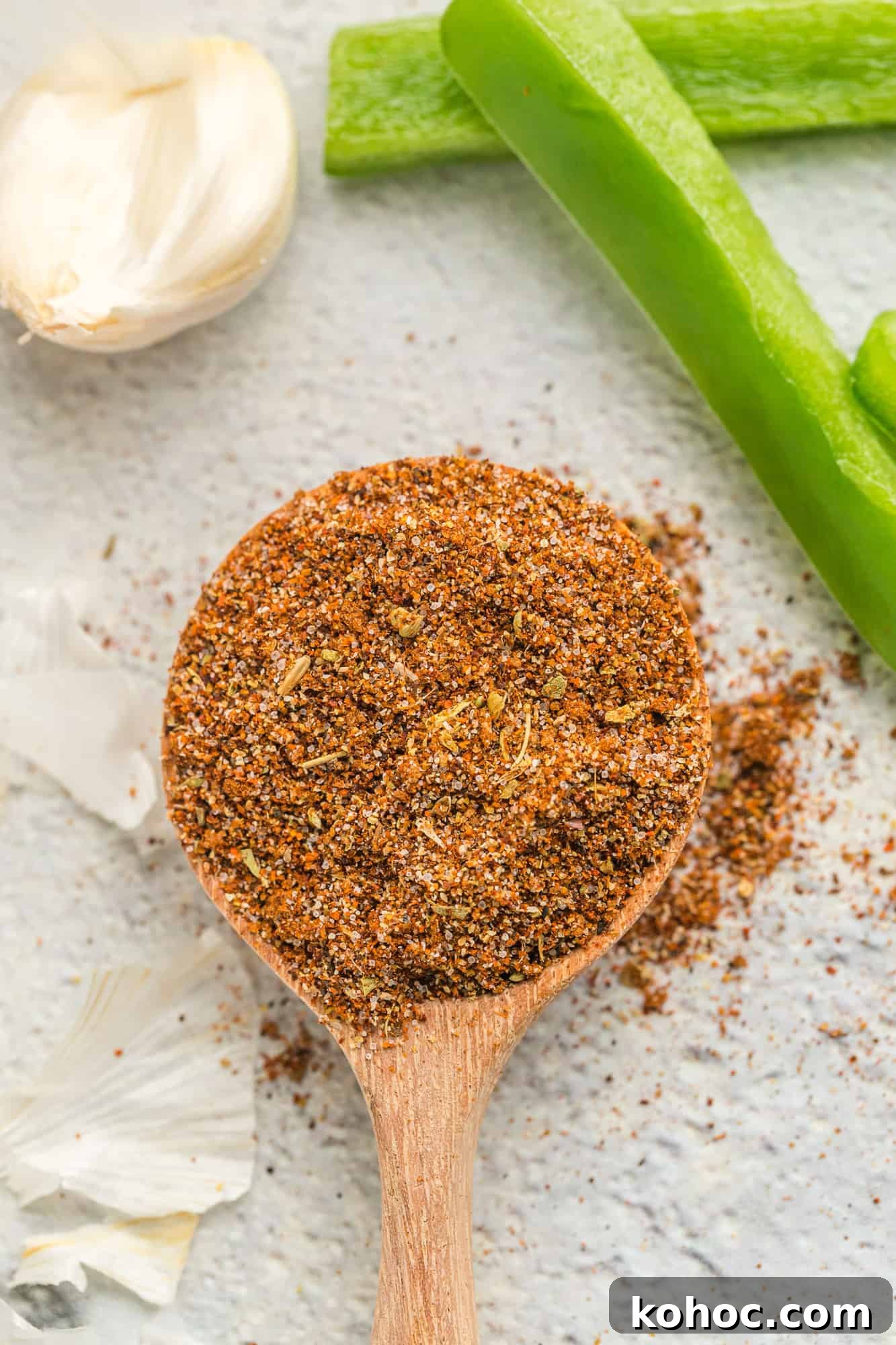 Fajita seasoning spilling off a small wooden spoon. 