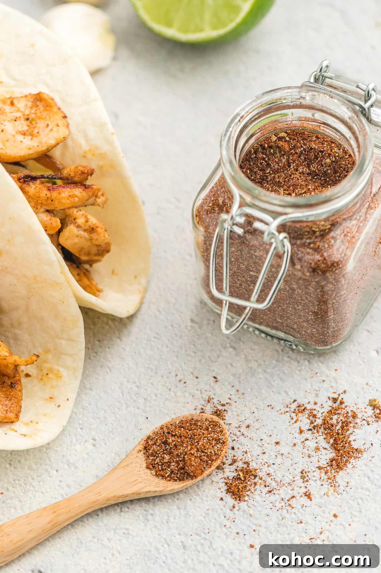 Fajitas in flour tortillas, jar of fajita seasoning next to them.
