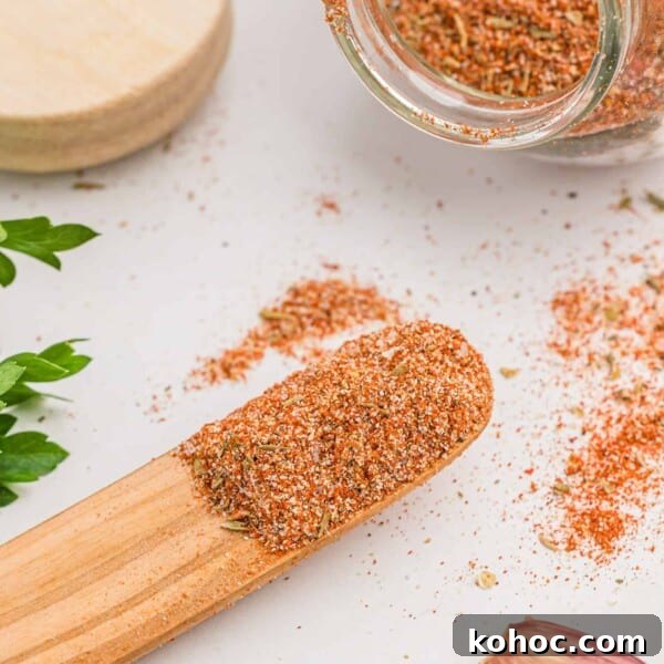Cajun seasoning on a small wooden spoon and in a jar.