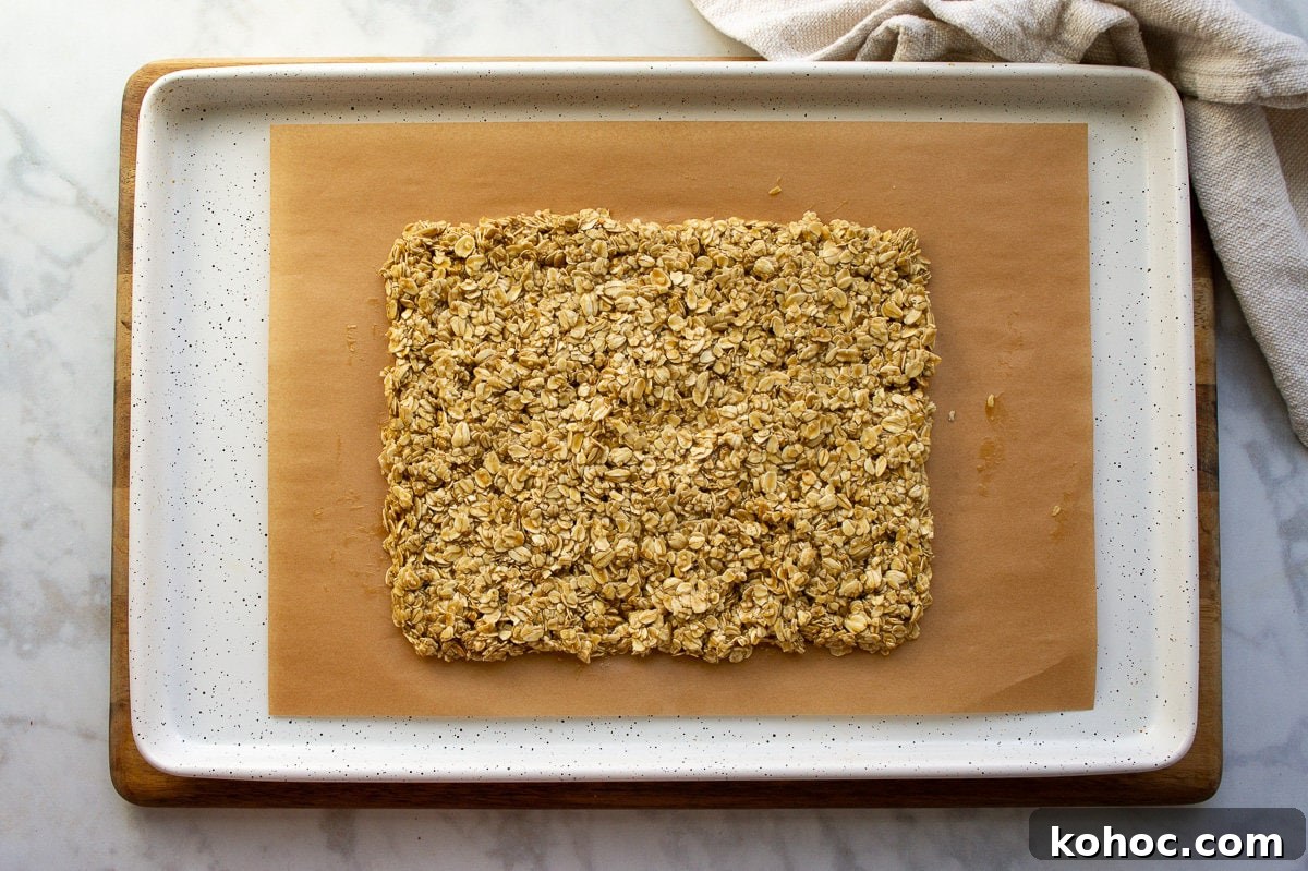 Baked Nut-Free Granola Bars Recipe 5 baking nut-free granola bars in a large rectangle on parchment paper.