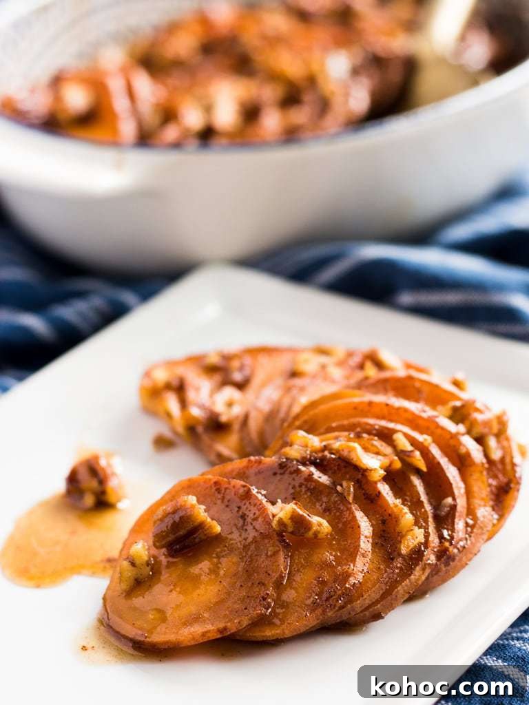Bourbon Maple-Glazed Sweet Potatoes 3 serving of sweet potato slices on plate with maple glaze and pecans.
