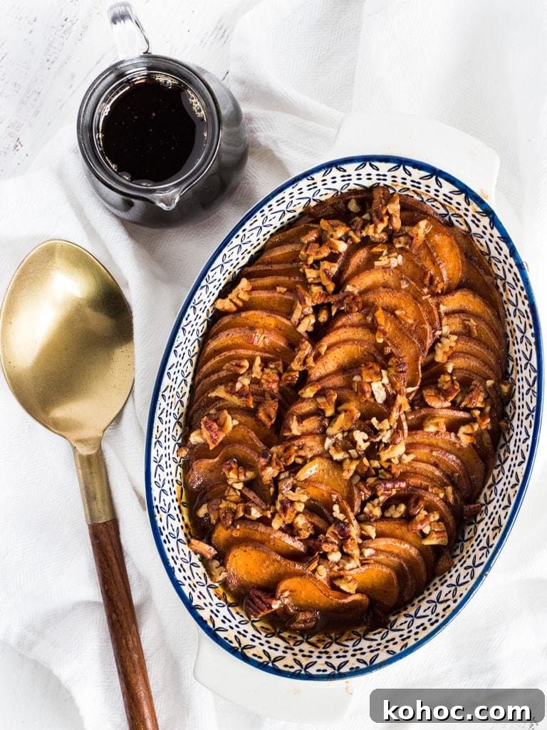 Bourbon Maple-Glazed Sweet Potatoes 5 bourbon maple sweet potatoes in a casserole dish next to a serving spoon.