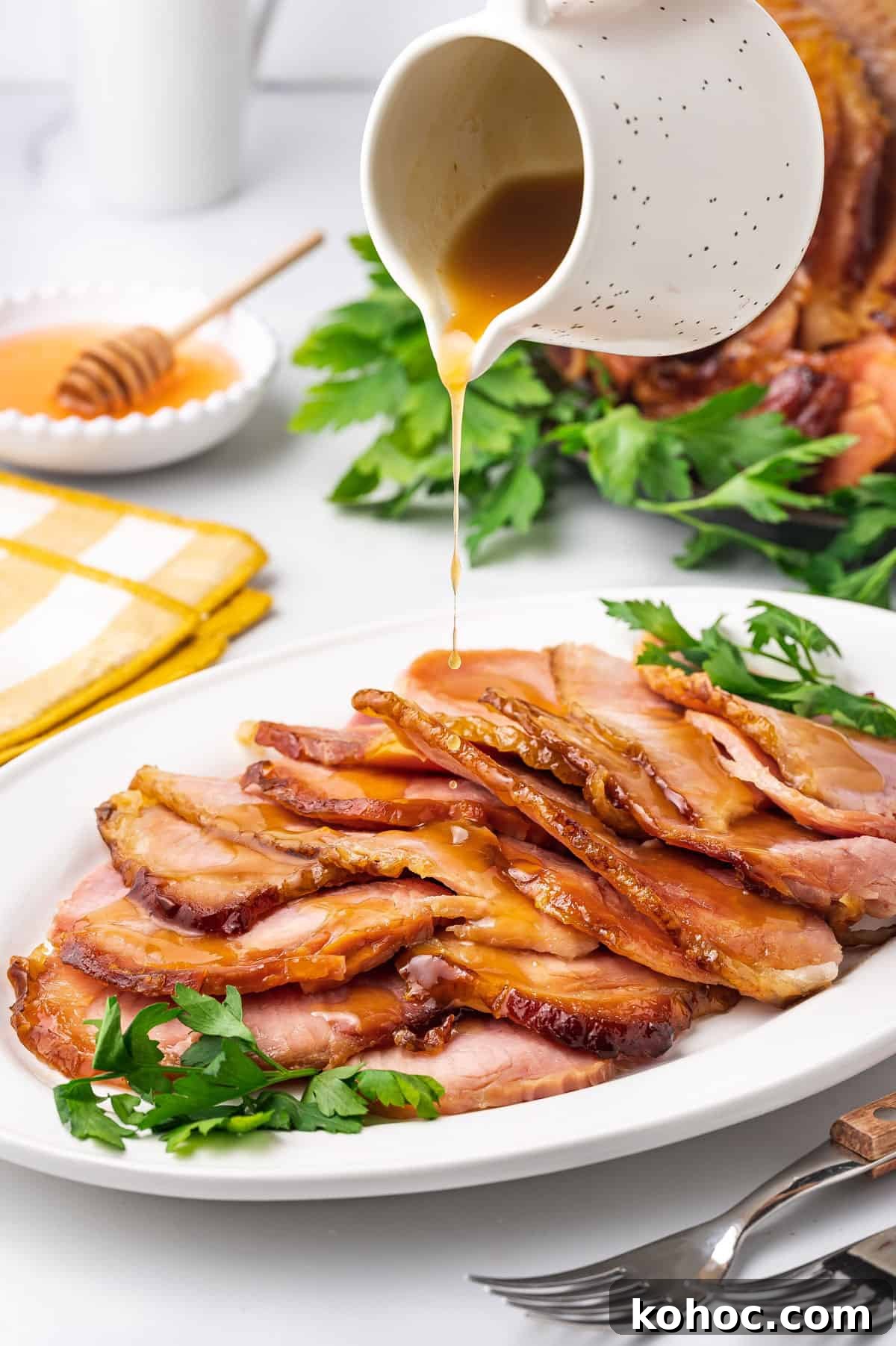 Slow Cooker Ham with Brown Sugar Glaze 10 Sauce poured over sliced slow cooker ham on a platter.