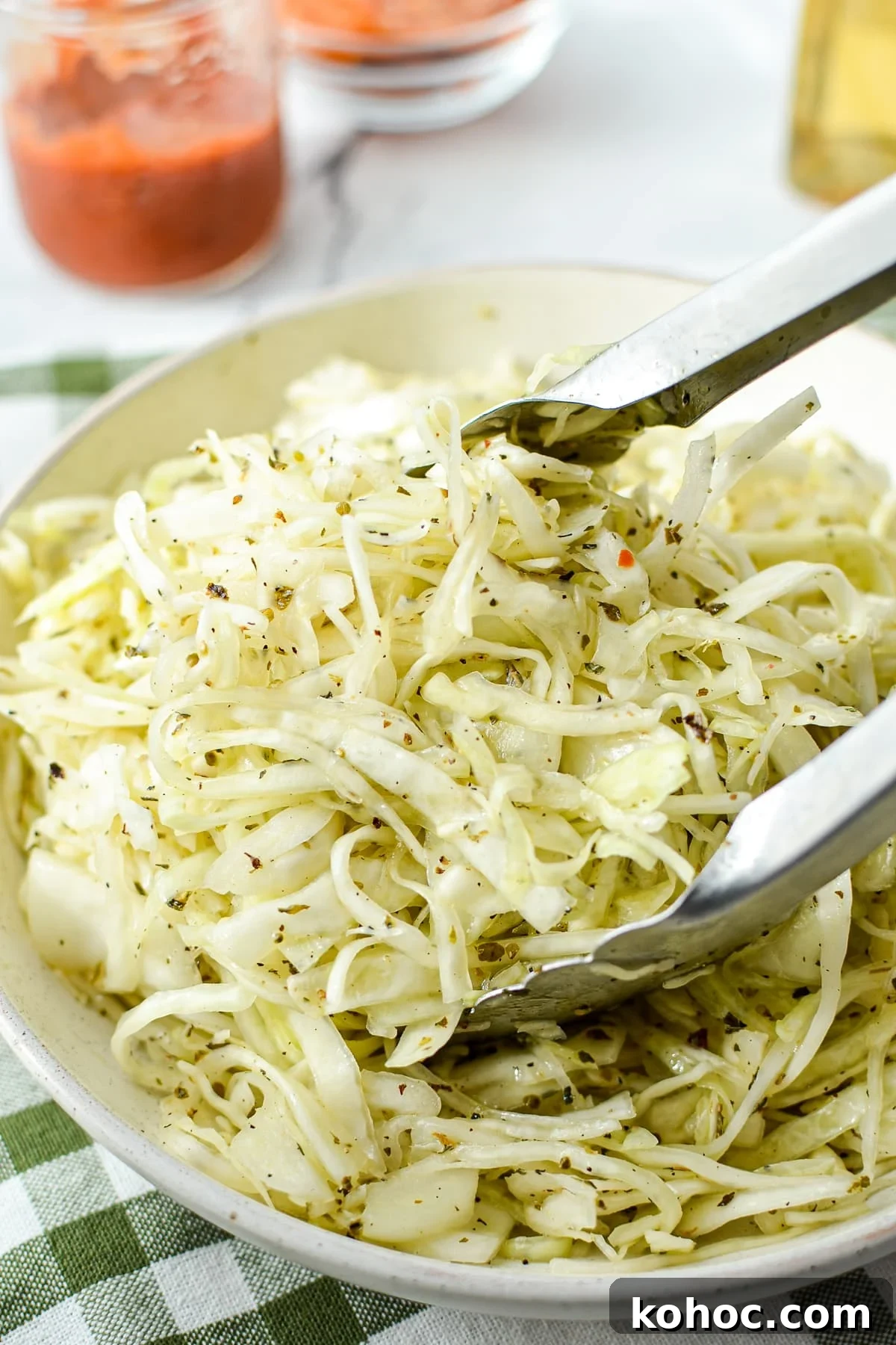 Swedish Pizza Salad: Tangy Cabbage Slaw with Dill 2 Tongs tossing a oil and vinegar coleslaw.