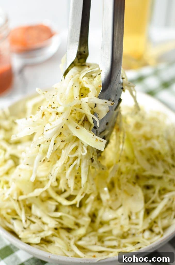 Swedish Pizza Salad: Tangy Cabbage Slaw with Dill 9 Tongs taking a portion of a coleslaw made with vinegar.