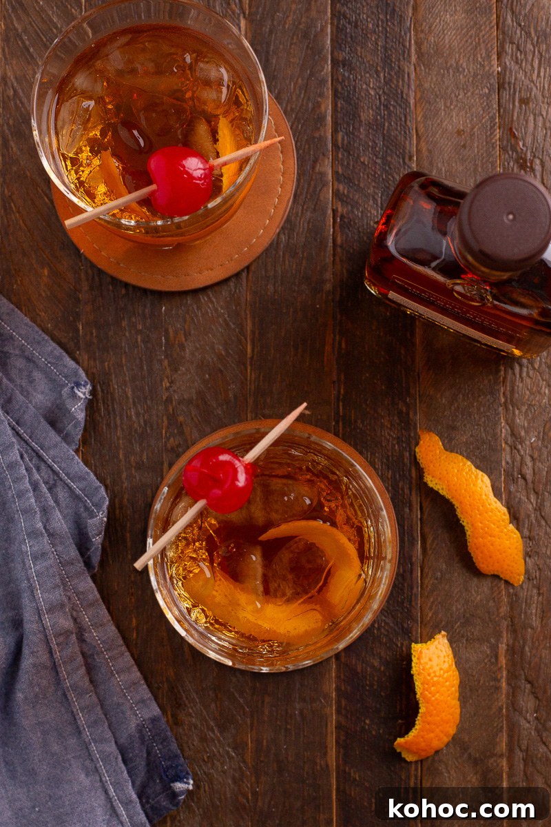 Classic Old Fashioned Cocktail Recipe with Bourbon 6 Two glasses of old fashioned cocktails sitting on wooden board.