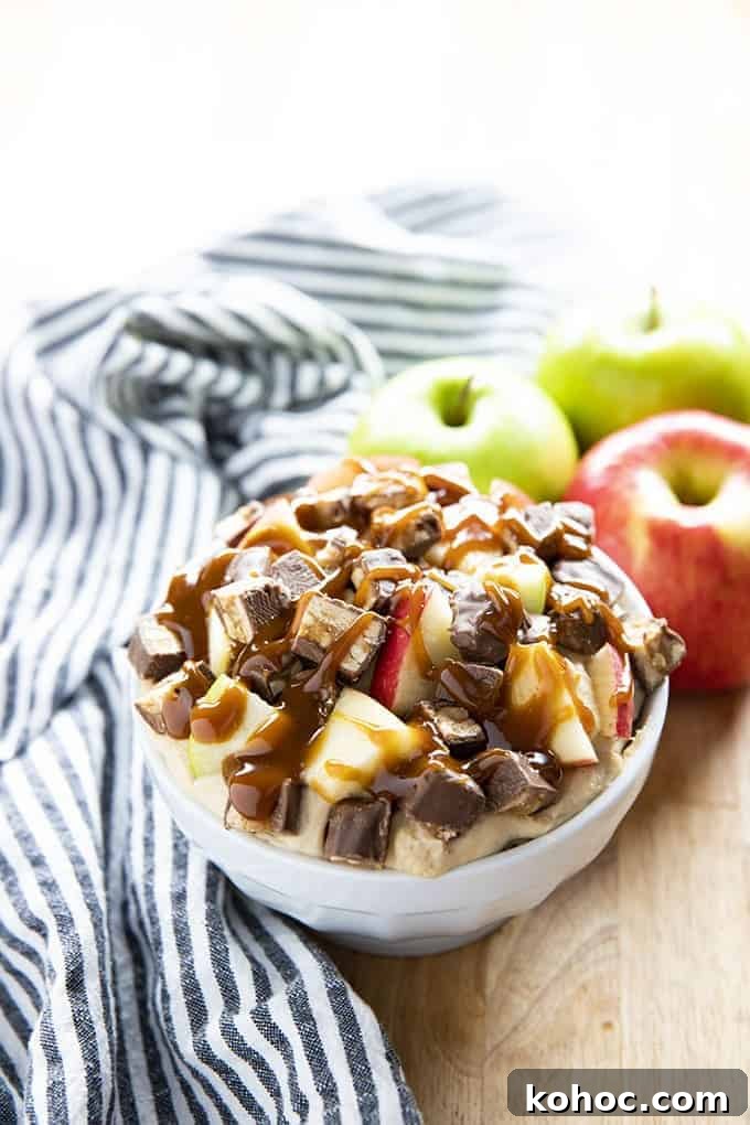 Snickers Caramel Apple Dip is a decadent cream cheese dip recipe for fall! Full of brown sugar, cinnamon, caramel, apples, and Snickers candy bars! caramel apple dip with snickers