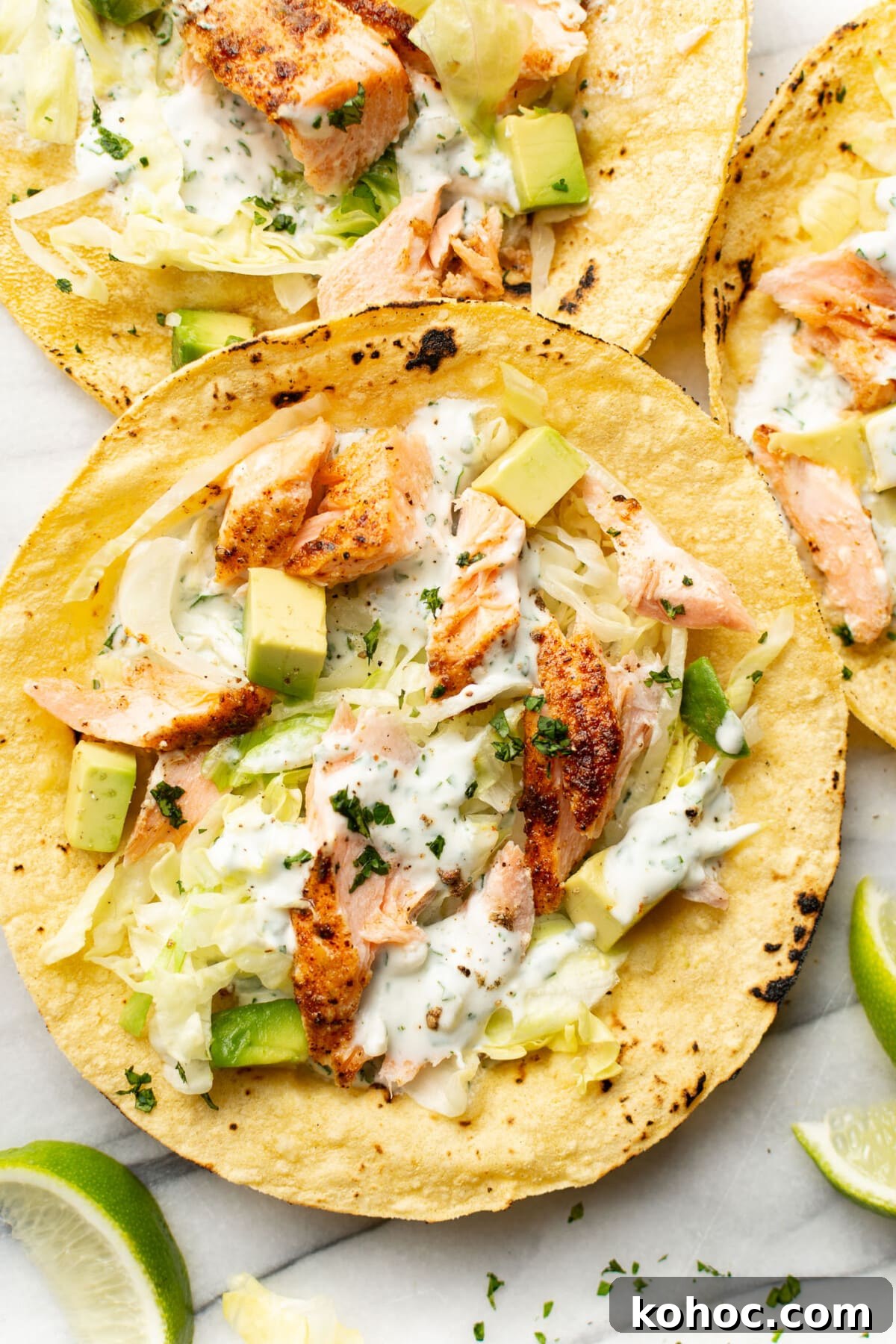 Crispy Baked Salmon Tacos with Lime Slaw 2 baked salmon tacos on a marble surface