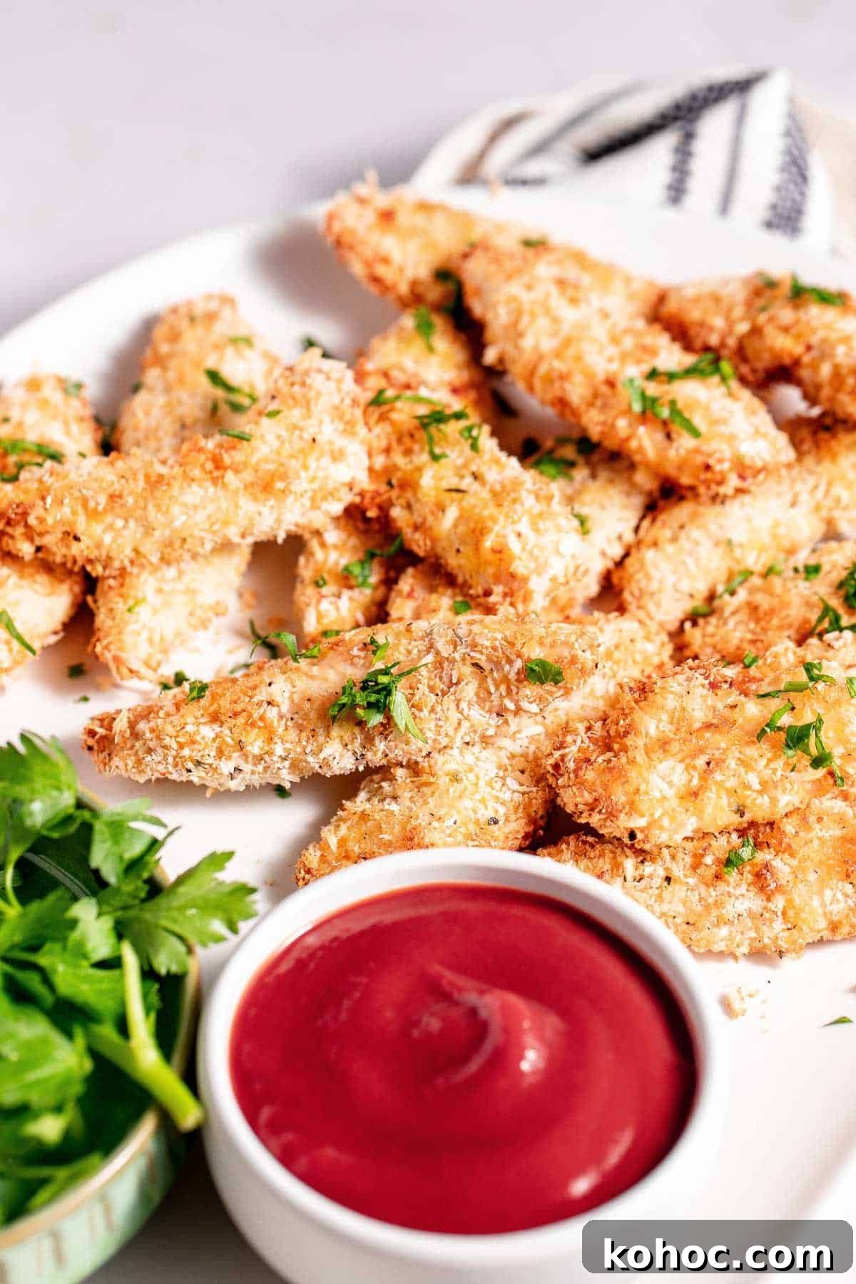 Air fried chicken tenders on a plate with a dipping sauce.