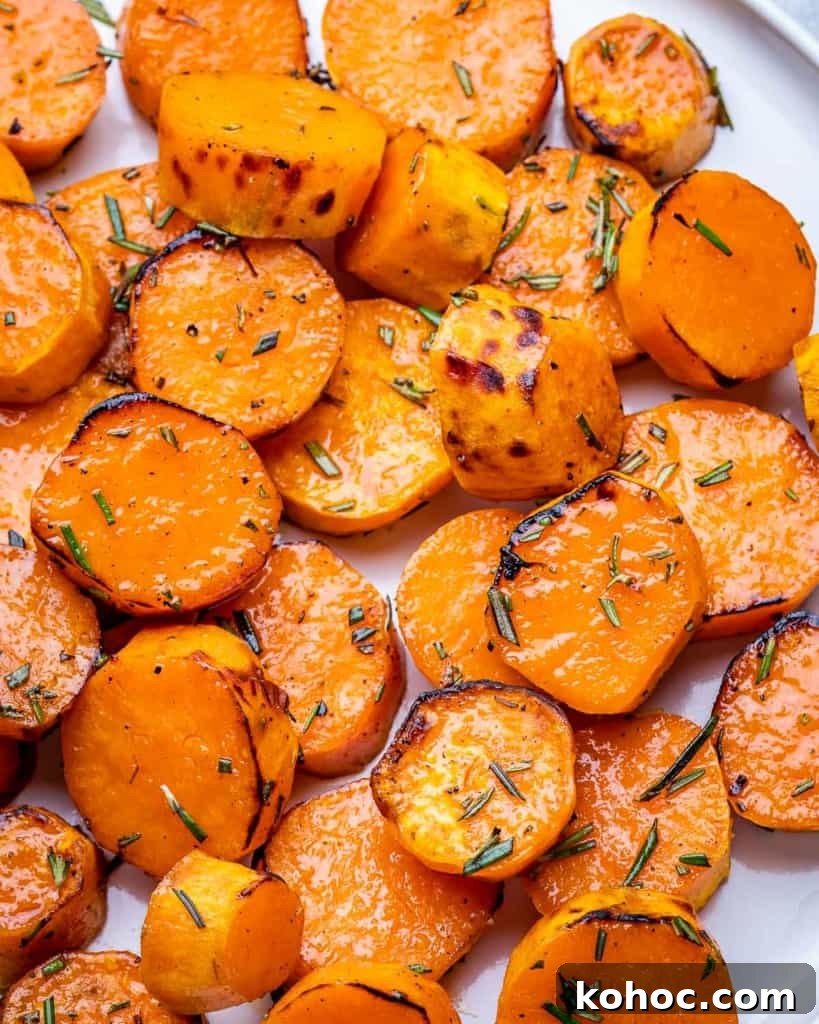 Crispy Roasted Sweet Potatoes with Garlic and Herbs 8 Browned roasted sweet potato rounds garnished with fresh rosemary.